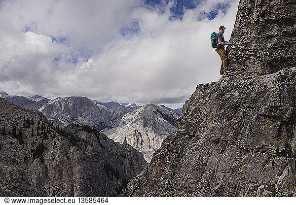 Man mountain climbing steep  craggy mountain face