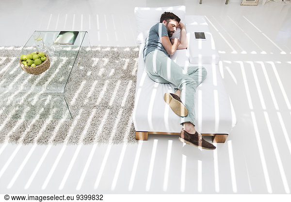 Man napping on daybed in modern living room