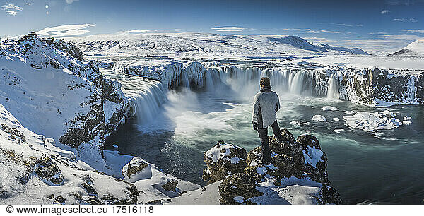 man observe frozen waterfall from aerial view named Godafoss