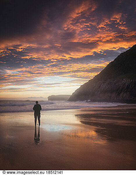 man observe the sunrise in front of the sea