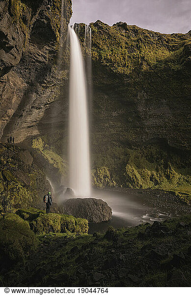 Man observing the size of a waterfall