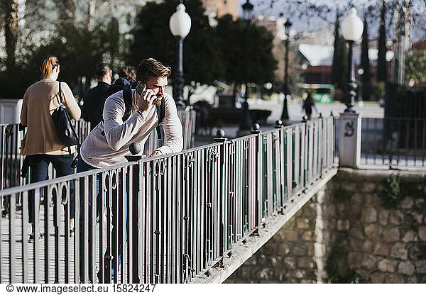 Man on a bridge talking on the phone