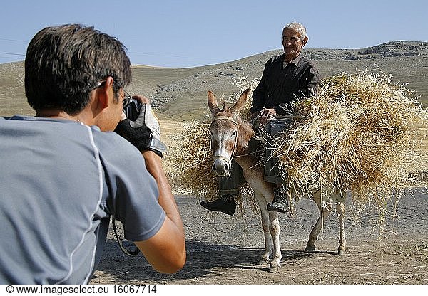 Man on a donkey east of Goris. Photographer taking pictures. Photo: Andr? Maslennikov/