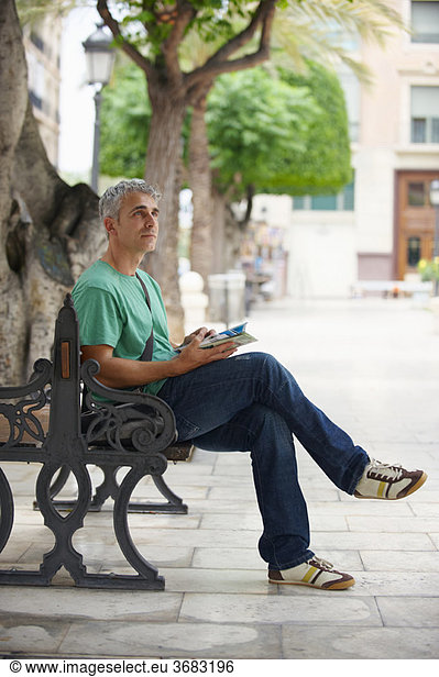 Man on bench in city square