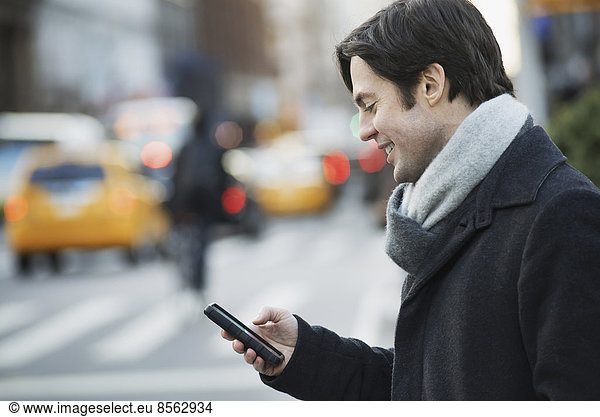 Man on busy street with smartphone