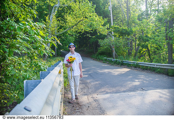 Man on roadside holding flowers