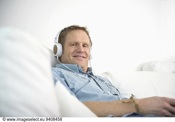Man on sofa listening to music
