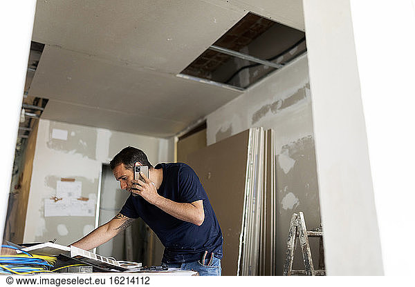 Man on the phone in a house under construction