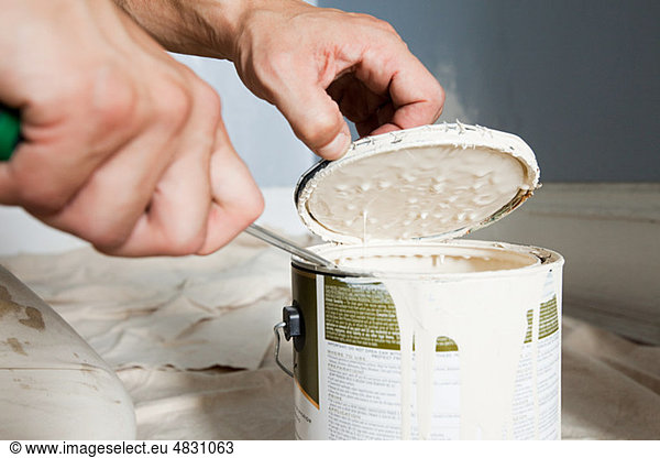 Man opening paint tin