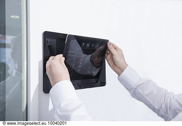 Man operating control panel on wall mounted  Munich  Bavaria  Germany