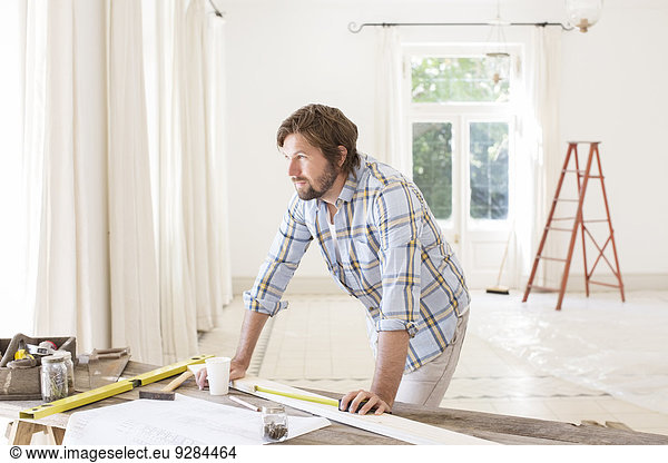 Man overlooking construction table in living space