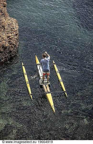 Man paddleboarding in sea