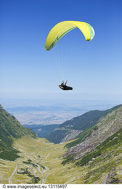 Man paragliding against clear sky