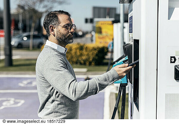 Man paying through smart phone at car charging station
