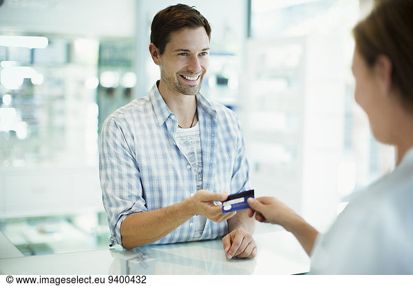 Man paying with credit card in drugstore