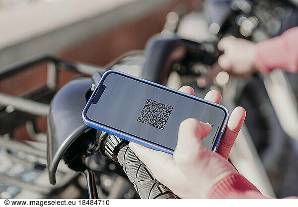 Man paying with smart phone at electric bicycle sharing system