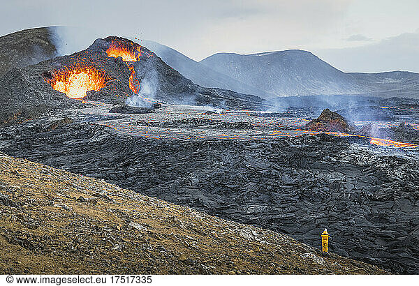 man photographing volcano caldera and lava