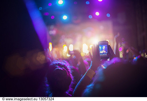 Man photographing with mobile phone at concert