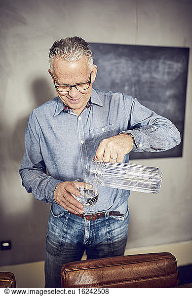 Man pouring water into glass