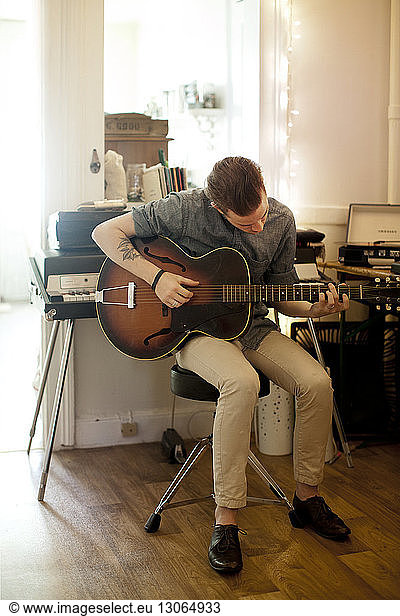 Man practicing guitar at home