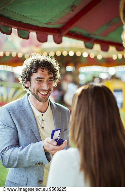 Man proposing to girlfriend in amusement park