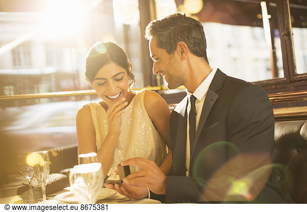 Man proposing to girlfriend in restaurant