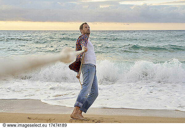 Man pulling rope on shore at beach