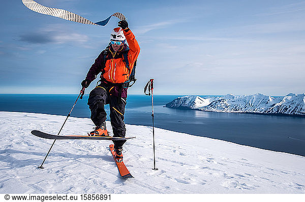 Man pulls off ski skins while backcountry skiing in Iceland