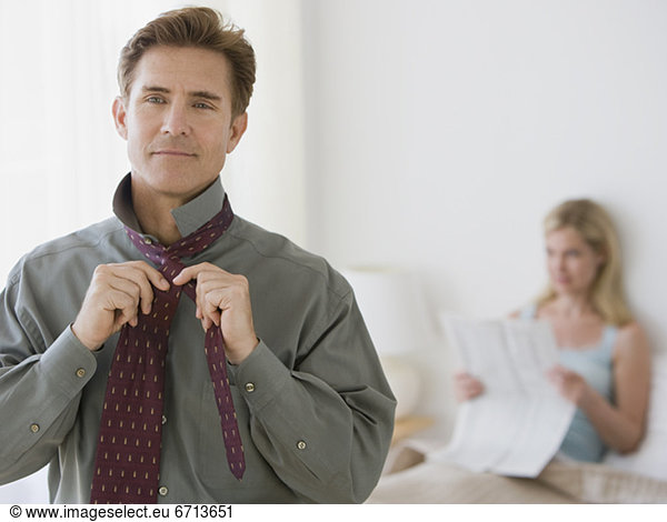 Man putting on tie