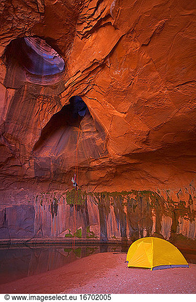 man rappelling into cave at Escalante's giant staircase
