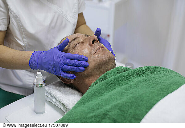Man receiving facial treatment in beauty spa