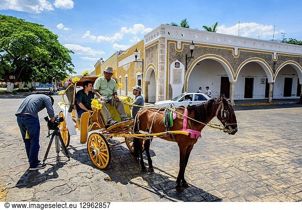 Man recording a horse car with a couple in Izamal  Yucatan  Mexico