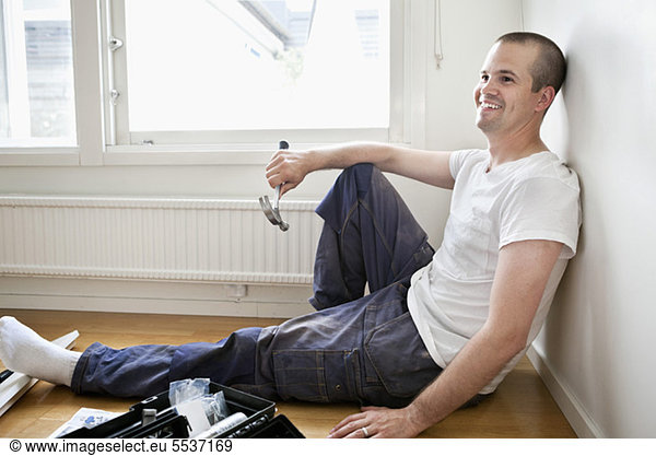 Man relaxing while holding hammer