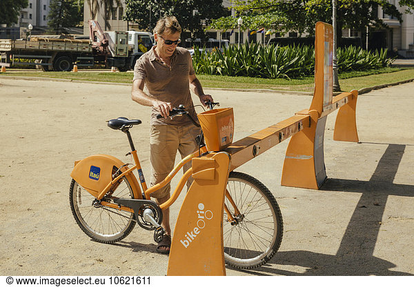 Man renting a public transportation bicycle in Rio de Janeiro