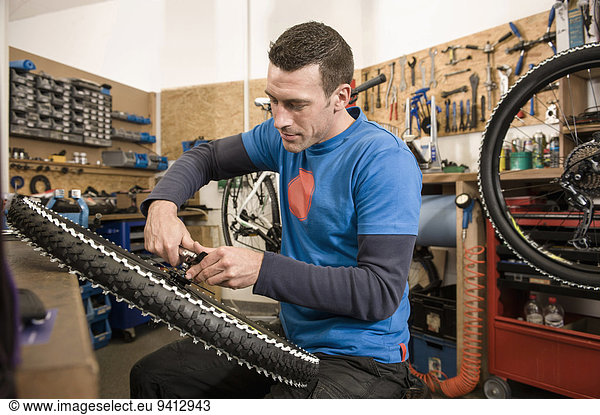 Man repairing bicycle in workshop