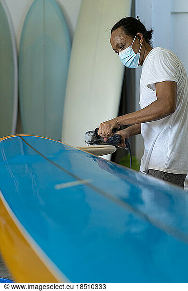 Man repairs surfboard  hands close up  Surfboard Workshop in Bal