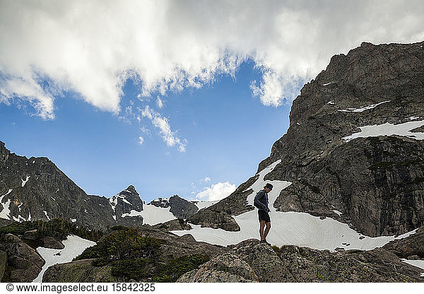 Man rests on rocks on trail run in Indian Peaks Wilderness  Colorado