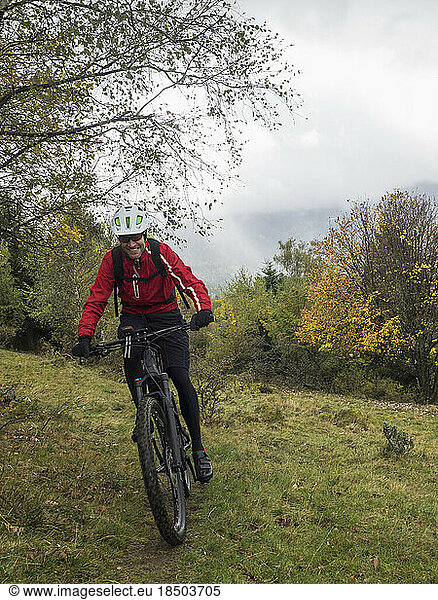 Man riding electric mountain bike on single trail  Vosges  France