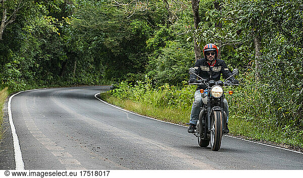 man riding his classic motorcycle at Khao Yai national park