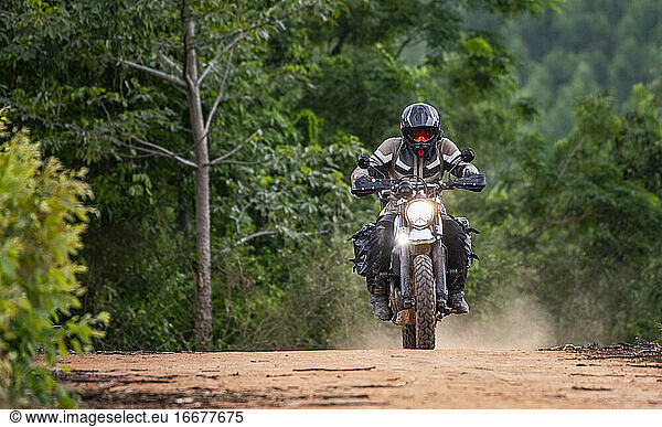 Man riding his motorbike on gravel road in Pak Chong / Thailand