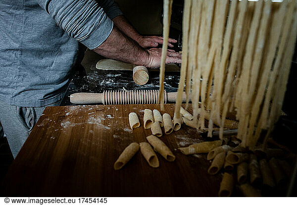 Man rolling out dough by hand for home made pasta