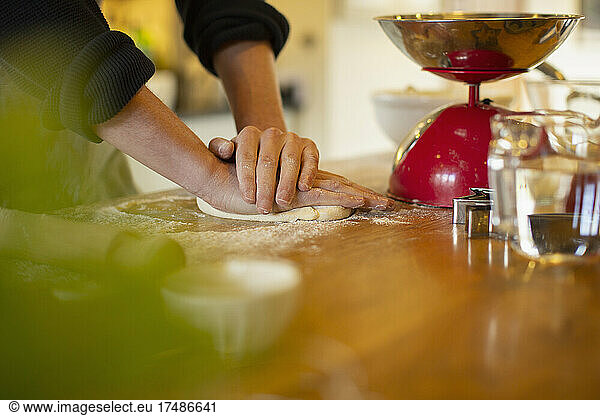 Man rolling out homemade dough on kitchen counter