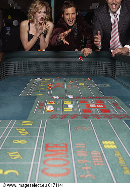 Man rolling the dice at a gambling table in a casino