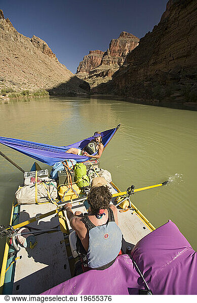 man rowing raft while woman lays in hammock  Grand Canyon  Arizona