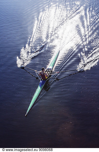 Man rowing scull on lake