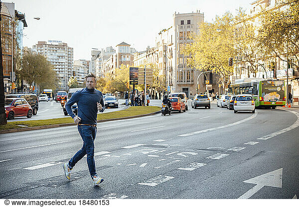 Man running and crossing road in city