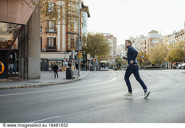 Man running on road in city