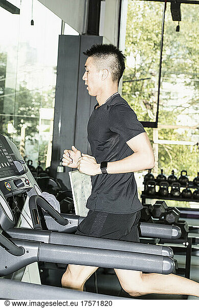 man running on treadmill at gym in Bangkok