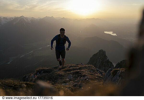 Man running up on Sauling mountain at sunset