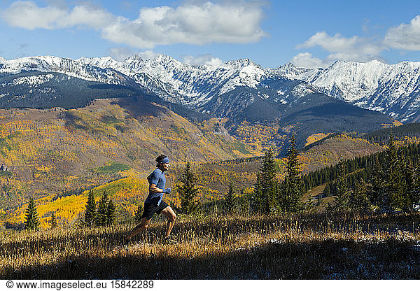 Man runs ridge with Gore Range mountain views in Vail  Colorado